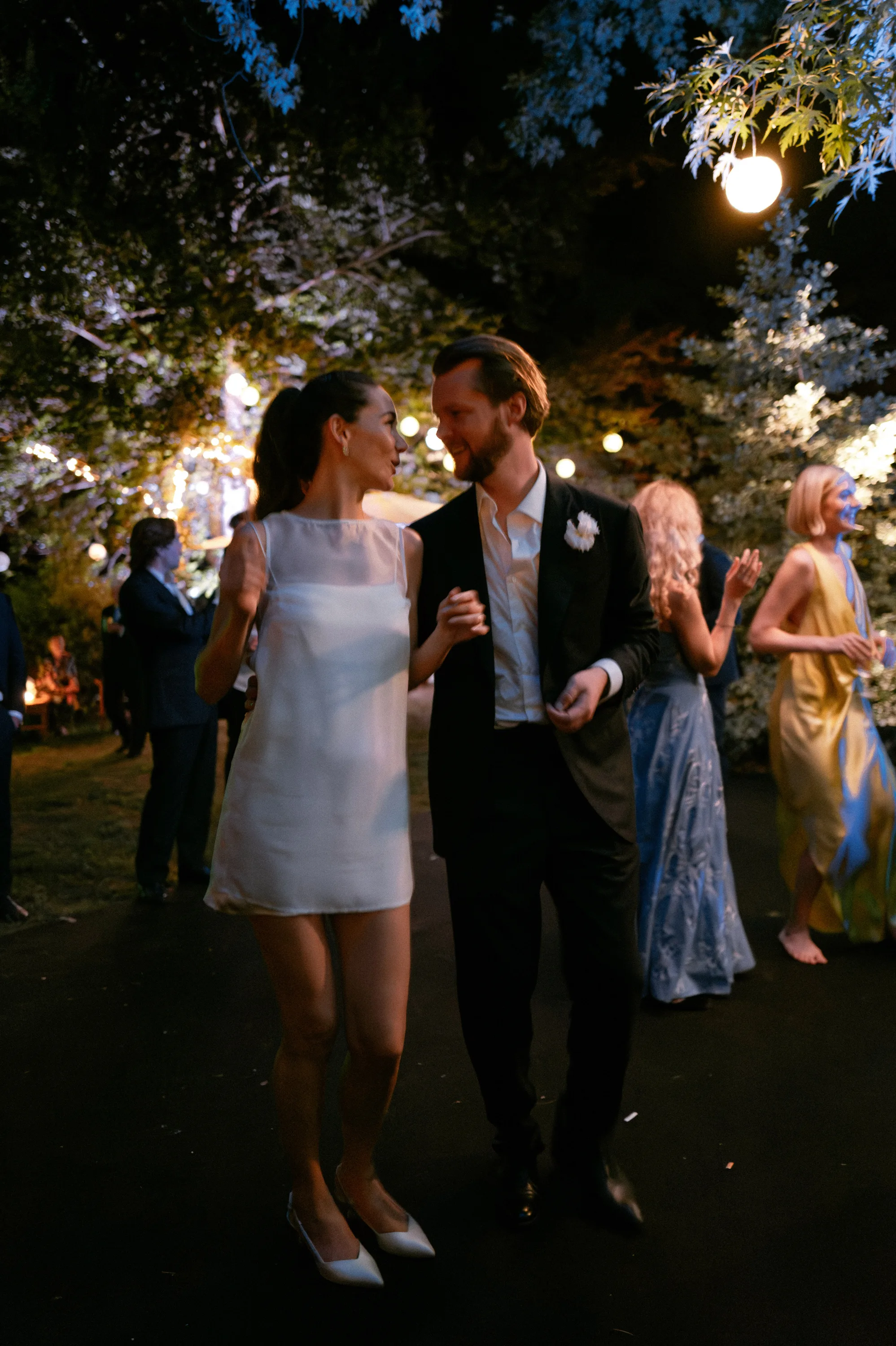 Bride in a mini dress dancing with her groom on the evening of her private Italian villa wedding.