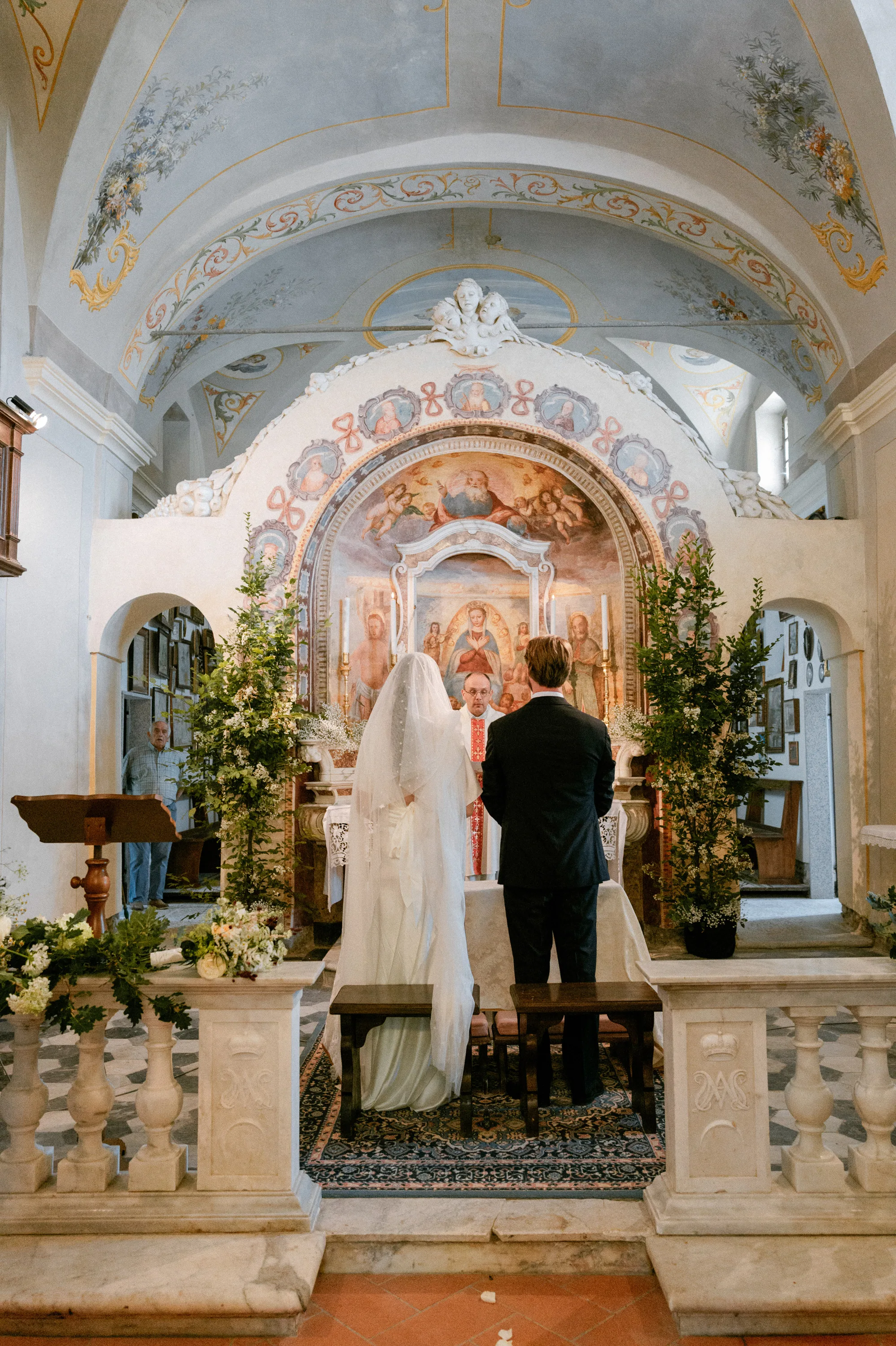 Bride and groom at the altar during their wedding ceremony at The Santuario della Madonna del Lago in Italy.