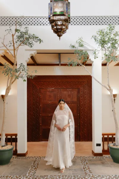 Bride framed in an ornate Arabesque doorway with a lantern at Al Maha Resort, a Dubai destination wedding