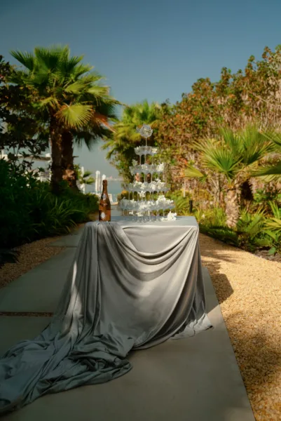 Garden path with draped fabric among palm trees at a Mediterranean coastal wedding venue styled by Zahra Studio Events