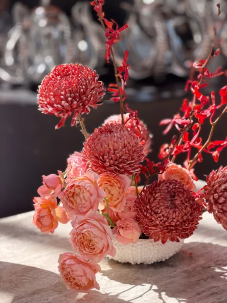 Lush coral and peach floral centrepiece with dahlias and roses, wedding floral design by Zahra Studio Events