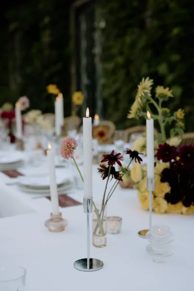 Outdoor wedding reception table with candles and autumnal florals in a Tuscan garden, design by Zahra Studio Events