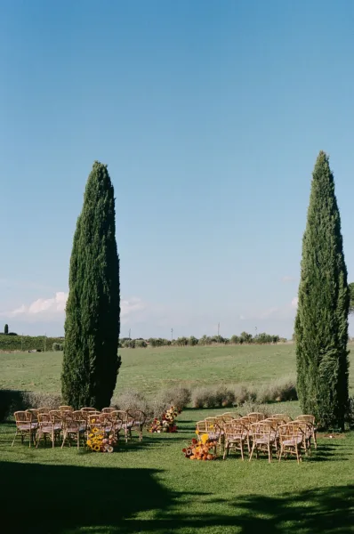 Tuscan countryside wedding setting with cypress trees and an outdoor ceremony designed by Zahra Studio Events