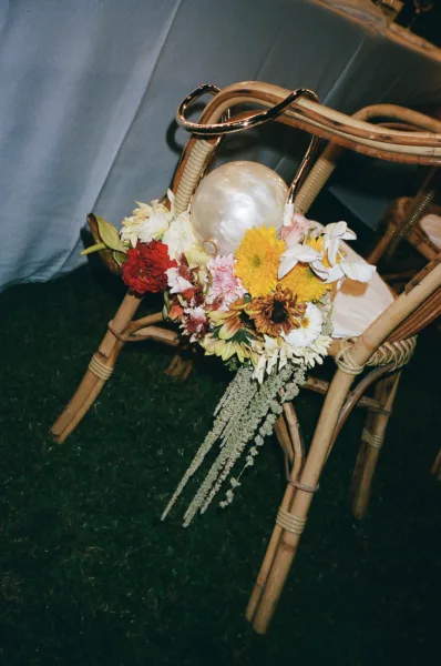 Cane ceremony chair decorated with a colourful sunflower arrangement, Tuscan wedding styling by Zahra Studio Events