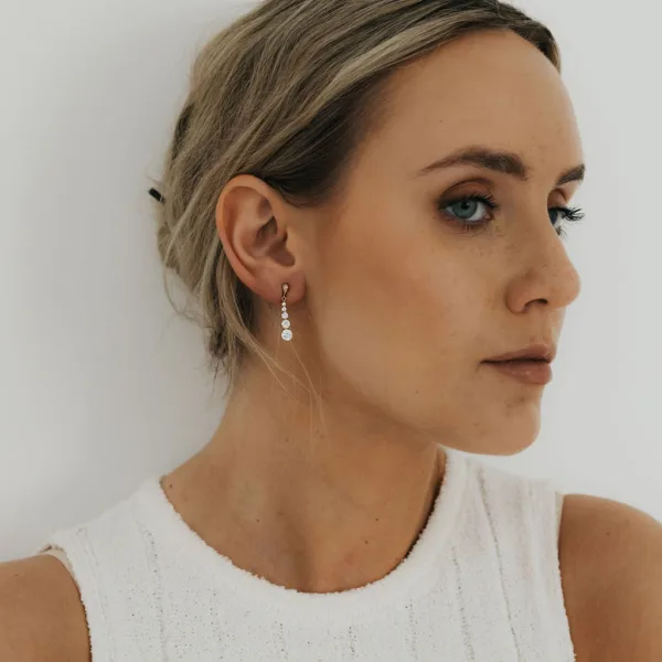 a model wearing a yellow gold drop earrings
