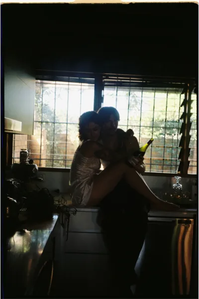 Groom carrying the bride through a softly lit interior in an atmospheric candid wedding photograph.