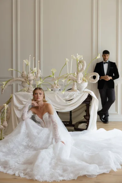 Couple in an opulent white room with draped fabric and sculptural decor, a luxury wedding designed by Zahra Studio Events