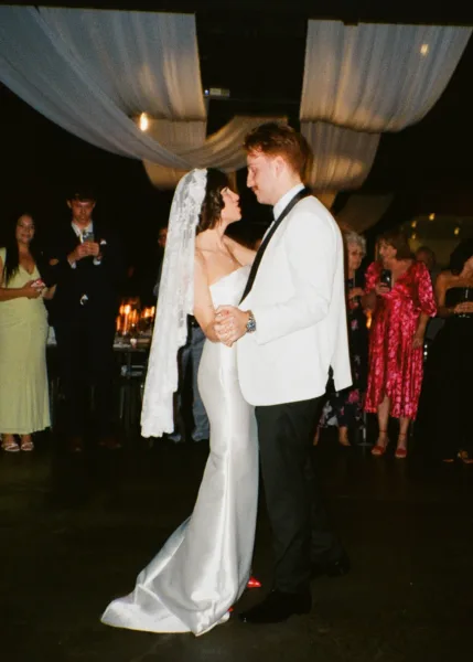 Bride and groom sharing their first dance, with the groom wearing a white dinner jacket, photographed on 35mm film.