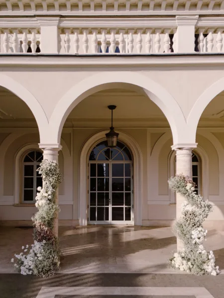 Arched loggia of Villa Miani in Rome decorated with white floral arrangements for a wedding designed by Zahra Studio Events