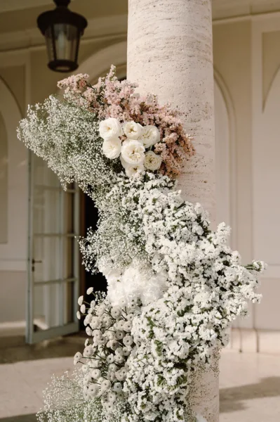 Column wrapped in a white baby's breath floral installation at Villa Miani in Rome, wedding design by Zahra Studio Events