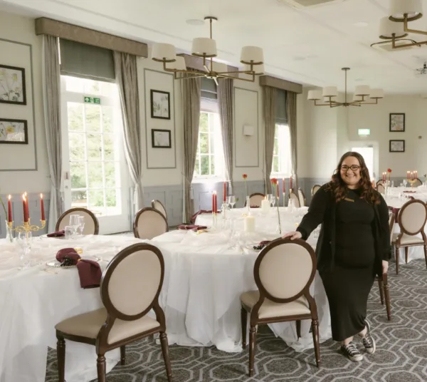 Lauren Batten, wedding planner, standing in an elegantly styled wedding reception venue in Berkshire