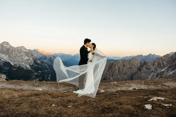 Bride and groom at blue hour, bride is holding her veil out in the wind