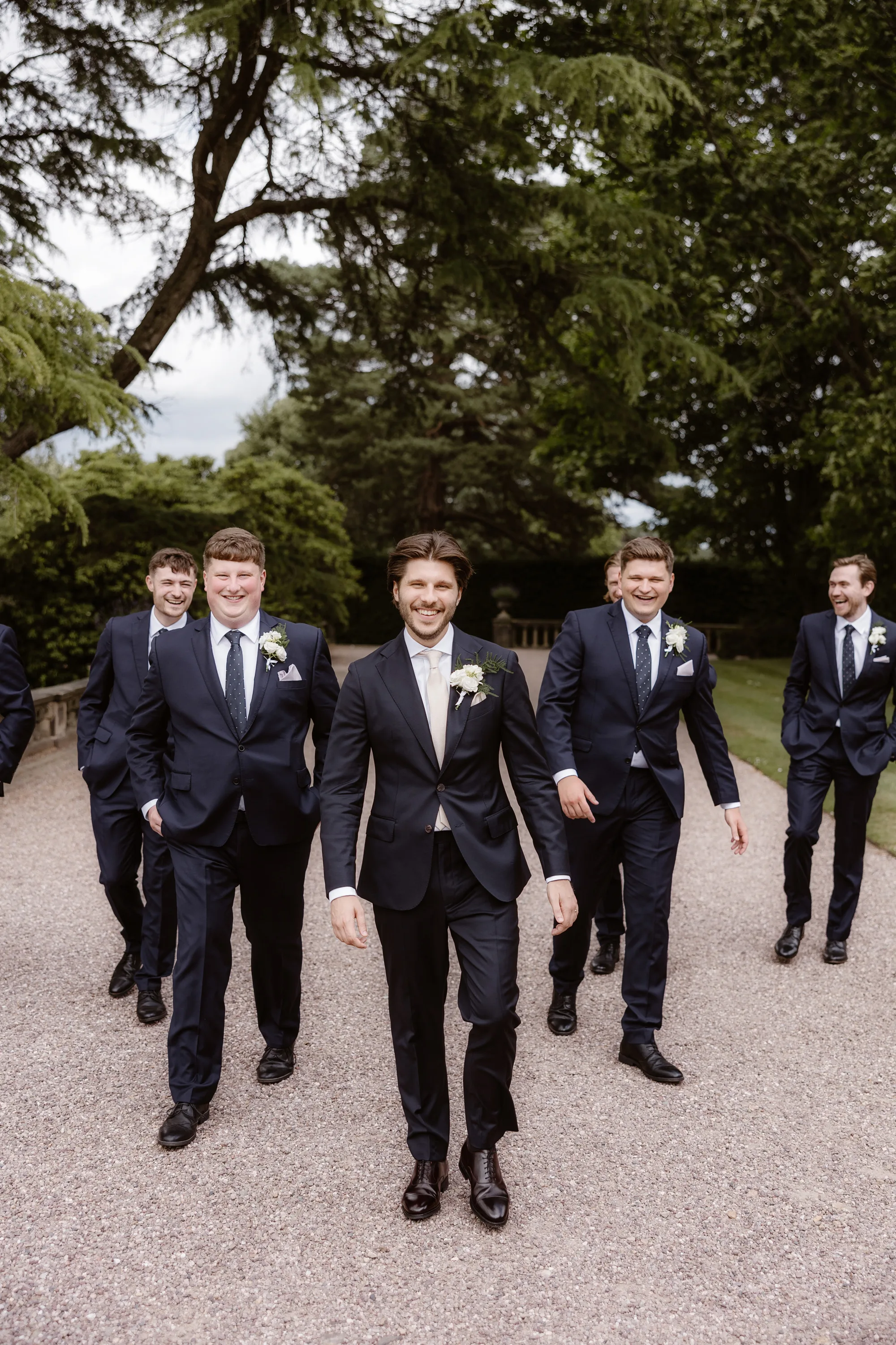 Capesthorne Hall Summer Wedding Jessica Sharpe Wedding Planner Jono Symonds Love My Dress.54 - Sophie & Dimitri's Beautiful, Relaxed & Elegant Wedding Weekend at Capesthorne Hall in Cheshire Groom and his groomsmen looking smart as they wander the ground of Capesthorne Hall in Cheshire. They wear dark blue suits from Moss Bros.