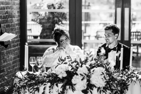 Black and white candid photo of wedding guests enjoying the reception