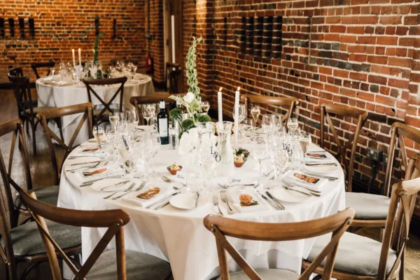 Elegant wedding banquet tables with white linens, tall candles, and floral centrepieces