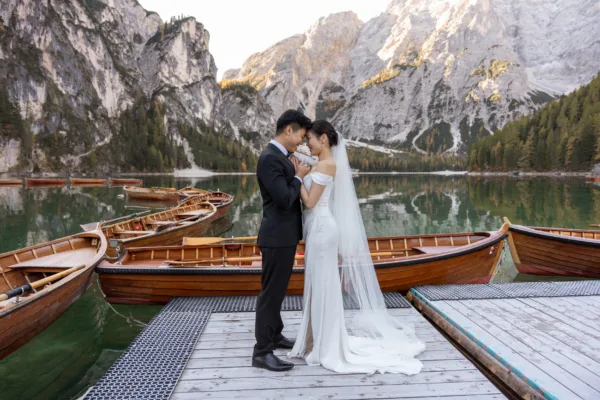 Bride and groom on the dock at the La Palifitta boathouse touching their foreheads together at Lake Braies