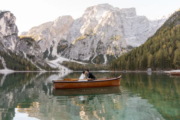 Bride and groom kissing on a boat rented from La Palifitta on Lago di Braies
