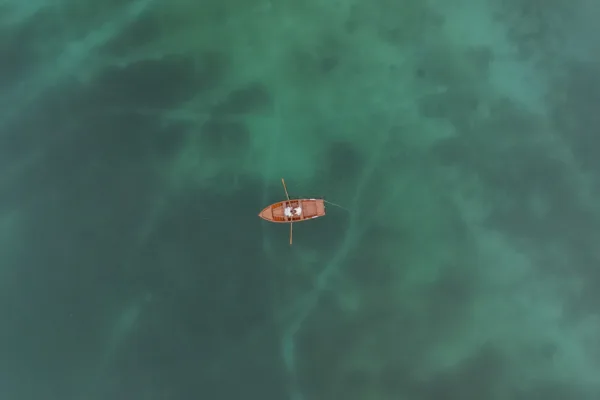 Drone view of Lago di Braies with bride and groom rowing the boat
