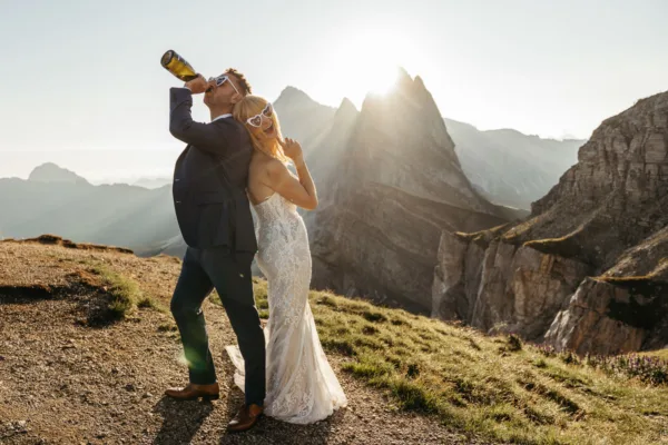 Bride and groom drinking champagne and celebrating their elopement on Seceda
