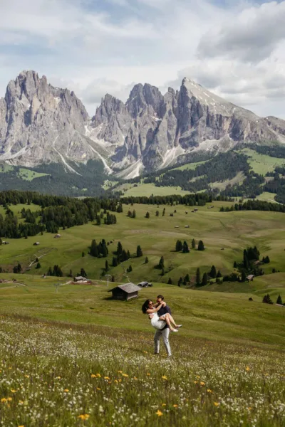 Bride and groom dancing in the wildflowers of Alpe di Siusi