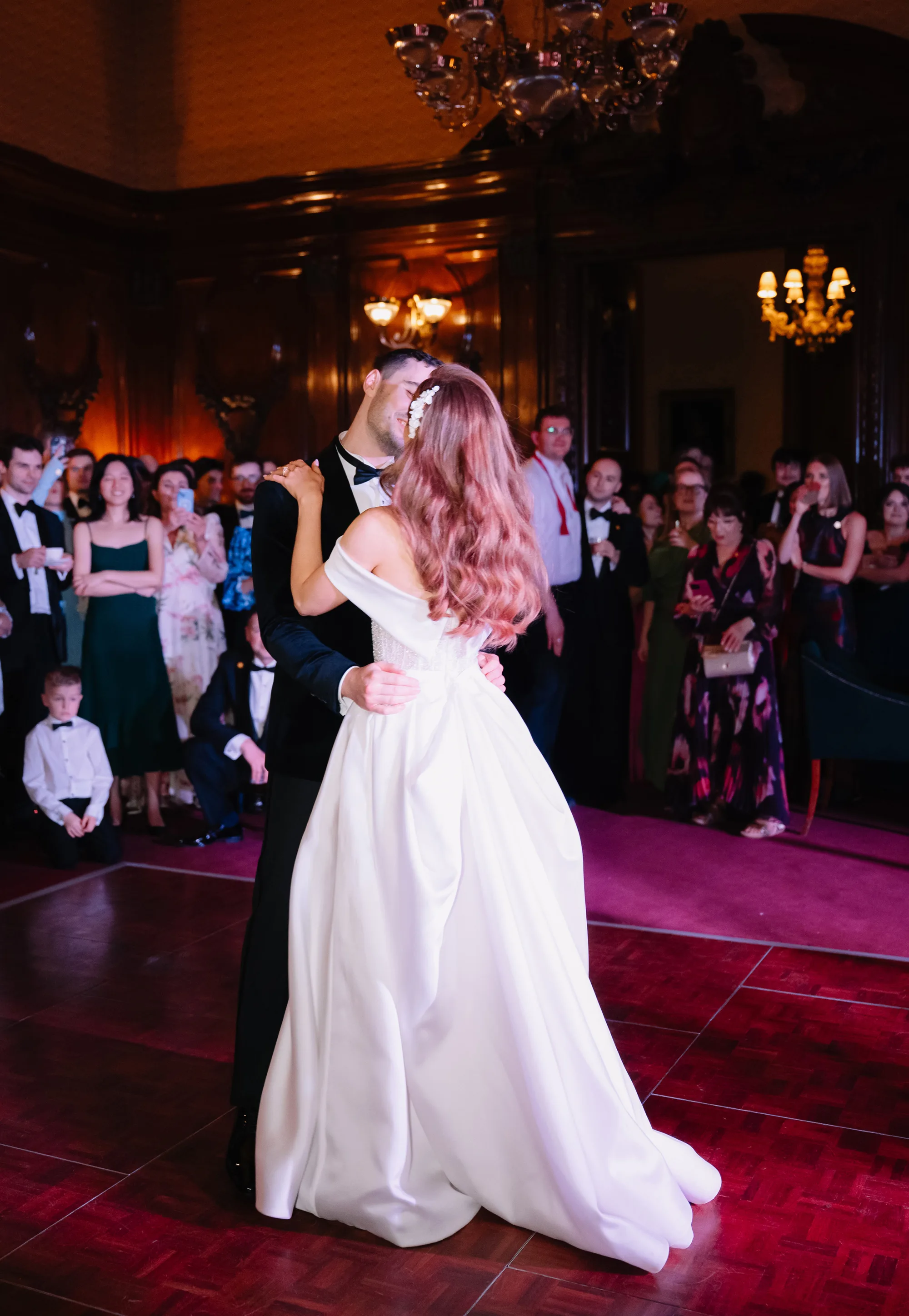 Bride and groom sharing their first dance at the evening wedding reception at Ashridge House in Hertfordshire.