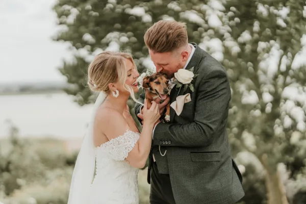 Newlyweds holding their pet at a dog friendly wedding venue in Kent