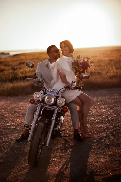 Newlyweds pose on a classic motorbike in front of the Kent coast