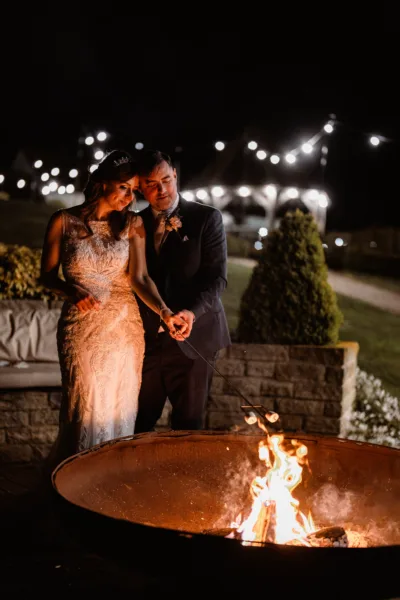 Bride and groom toast smores during their wedding party
