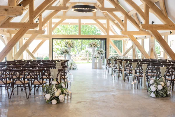 A barn wedding venue in Kent dressed for a wedding ceremony, with open bifold doors to the garden
