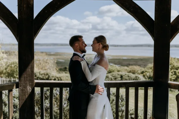 Newlyweds share a moment on their wedding day, in front of the Kent estuary