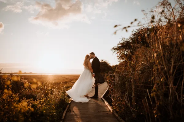Newlyweds on the Kent Coastal path share a kiss at twilight