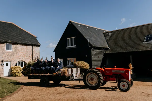 Groomsmen on a vintage tractor travel to a wedding at The Harty Estate in Kent