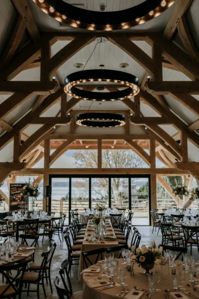 Wedding barn with glass windows overlooking the Kent estuary, dressed for a wedding breakfast