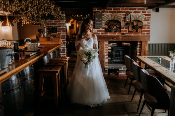 A bride walks through The Harty Estate's private wedding pub