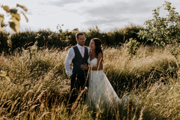 Newlyweds among the long grasses of The Harty Estate orchard