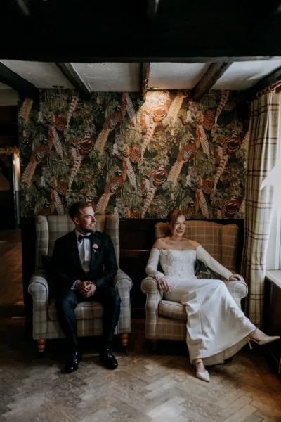 Newlyweds relax in armchairs at The Harty Estate barn wedding venue