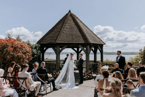 An outdoor wedding ceremony at The Harty Estate, overlooking the Kent estuary