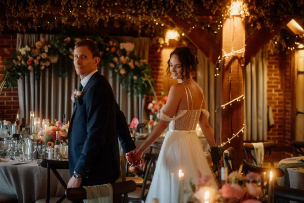 Newlyweds hand in had walk into their Kent Barn wedding breakfast