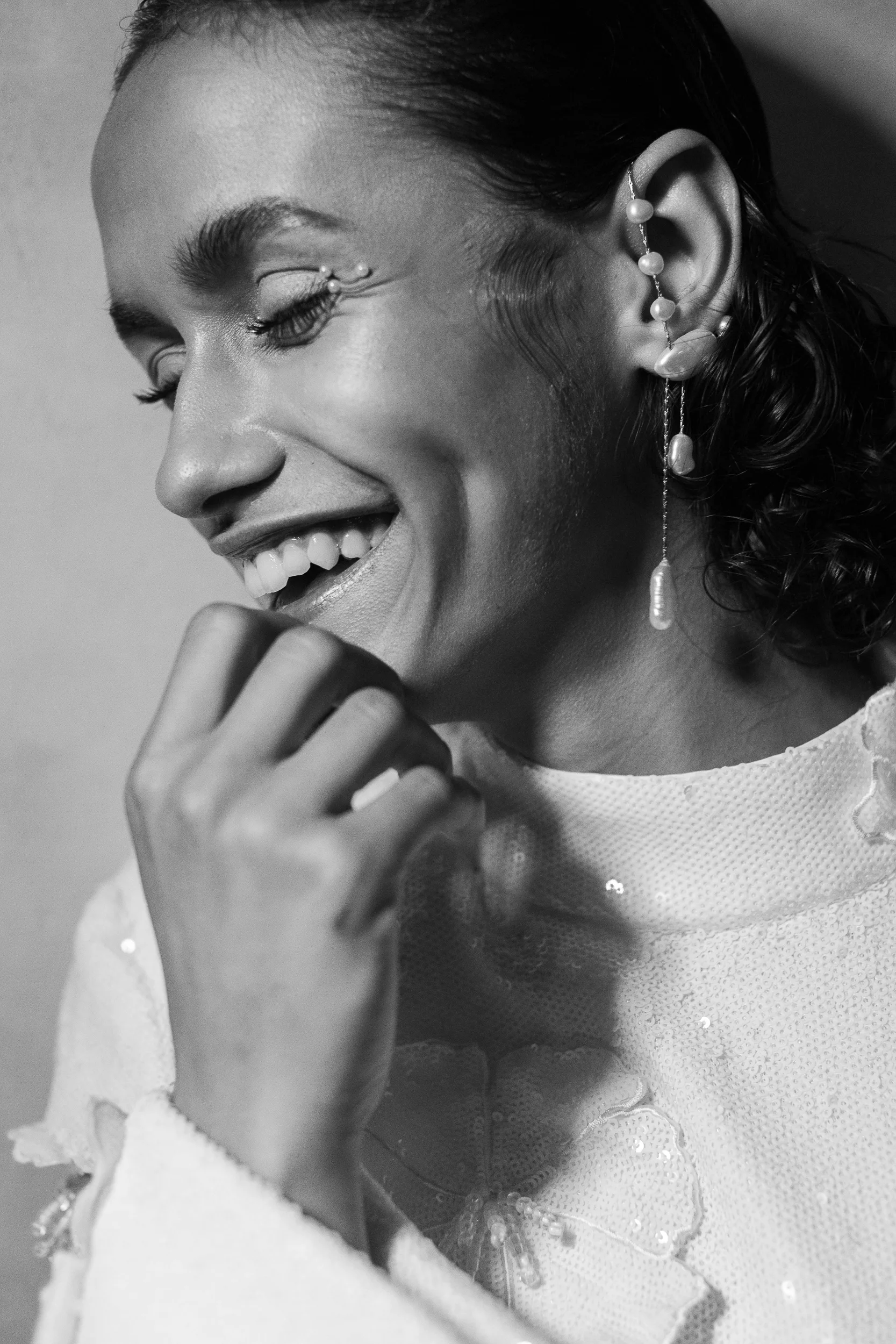 Black and white bridal portrait showcasing pearl earrings and crystal eye makeup.