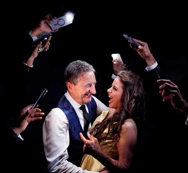 Wedding guests dancing together surrounded by illuminated mobile phones