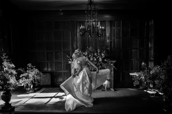 Black-and-white bride moving through an elegant wood-panelled wedding venue.