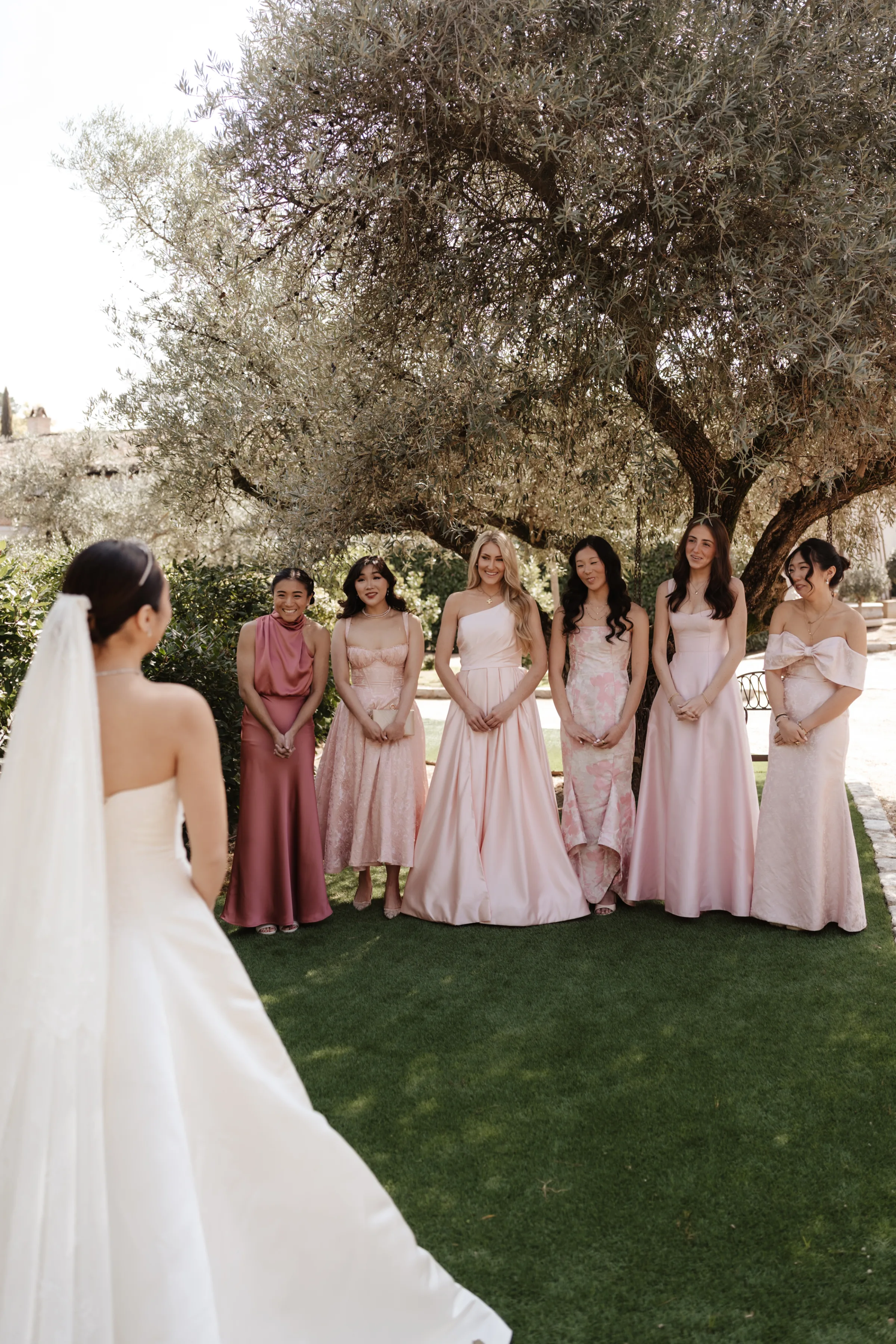 Wedding Toledo Spain Sam Sparks Photography 38 - A Multicultural Wedding in Toledo, Spain, with Korean Heritage and Deep Southern Roots Bridesmaids in various shades and styles of pink dresses looking at the bride