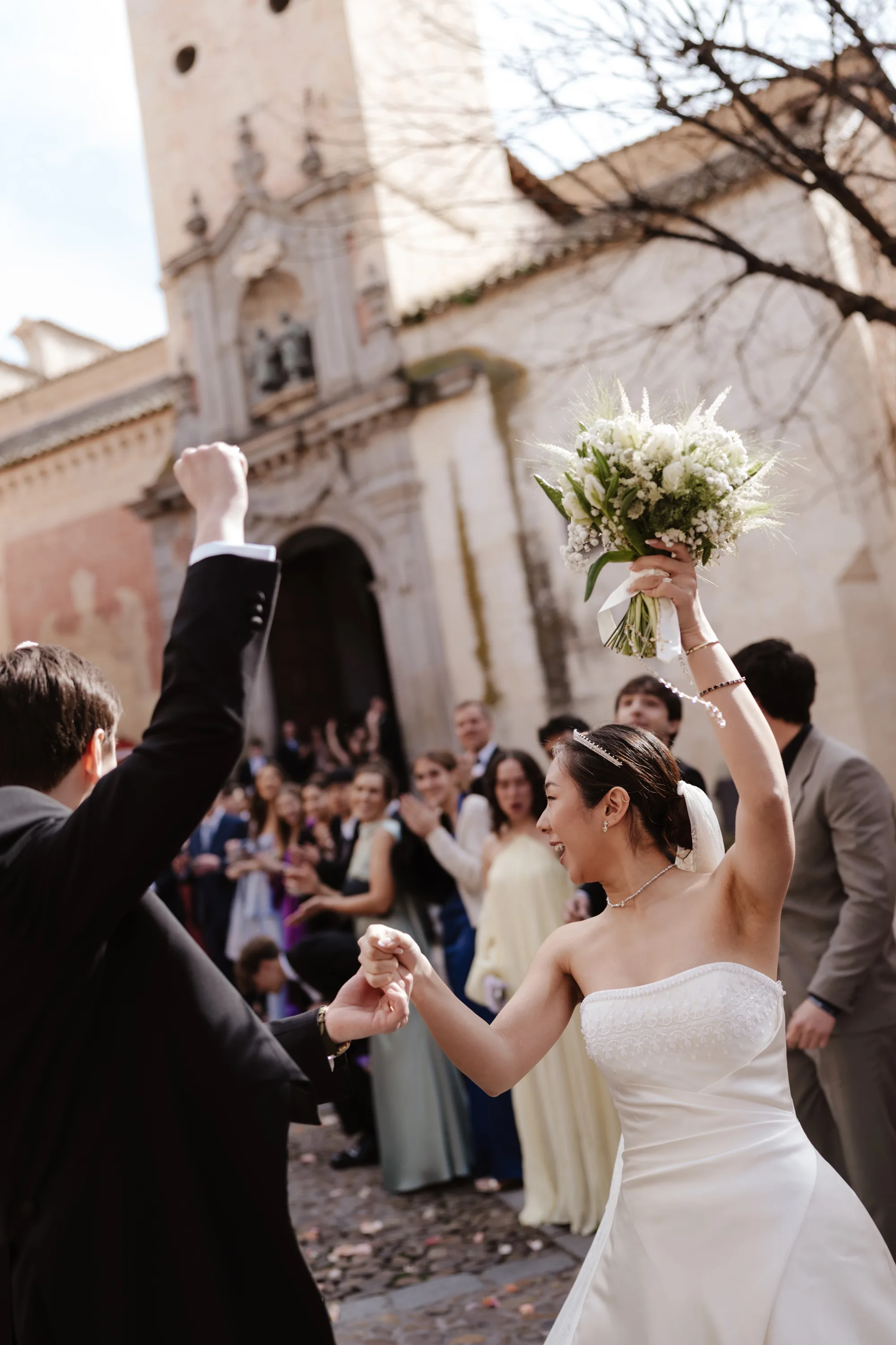 Wedding Toledo Spain Sam Sparks Photography 75 - A Multicultural Wedding in Toledo, Spain, with Korean Heritage and Deep Southern Roots Bride and groom exiting their Catholic wedding ceremony at the Santos Justo y Pastor church in Toledo, Spain to be greeted by their bridal party and showered in confetti.