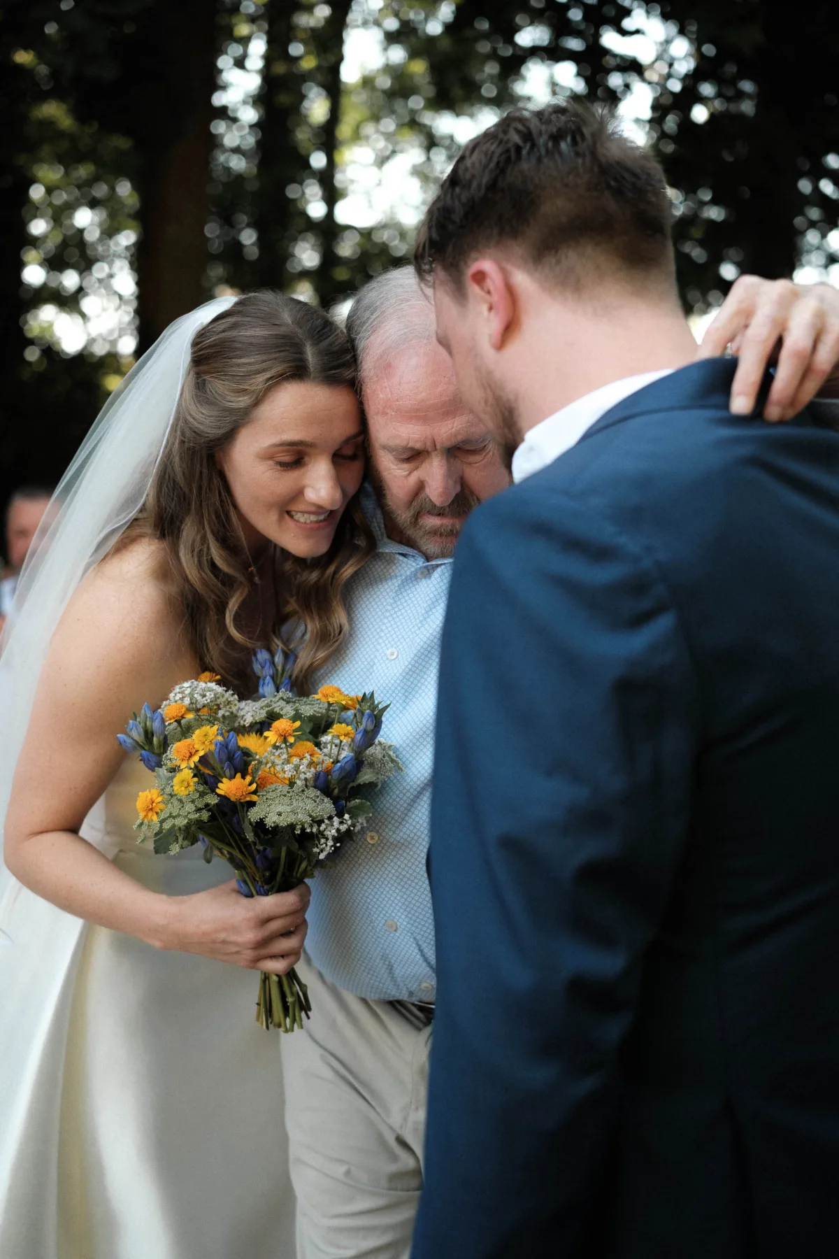 Bride, her father and brother have a tender moment before walking down the aisle together